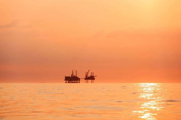 墨西哥湾日落时石油平台的剪影 - 图片来自 Lukasz Z / AdobeStock