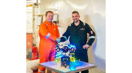 Alexander Bahr, Hydromea COO, and Keiran Hope, ACE COO, shake hands on service partnership with EXRAY wireless ROV in the center. Image courtesy Hydromea