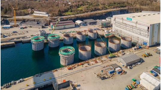 Hywind Tampen structures being floated out of the drydock at Stord, Norway. Photo from Aker Solutions / Lars Melkevik.