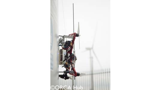 The Imperial College London drone demonstrating autonomous UAV sensor placement on a wind turbine at the ORE Catapult facility in Blyth. The drone is equipped with a winch-tethered magnet and passive wheels capable of perching on, and sliding along, both vertical and horizontal surfaces.