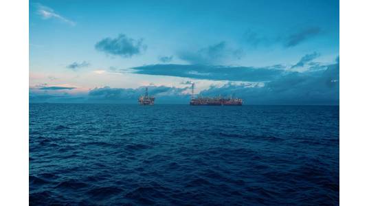 An FPSO next to an oil platform - Credit; Igor Kardasov/AdobeStock