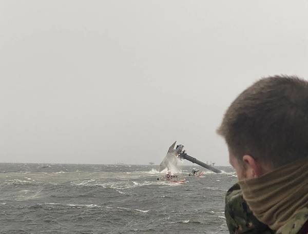 The crew of the Coast Guard Cutter Glenn Harris pulls a person from the water April 13, 2021 after a 175-foot commercial lift boat Seacro Power capsized 8 miles south of Port Fourchon, La. (U.S. Coast Guard photo courtesy of Coast Guard Cutter Glenn Harris)