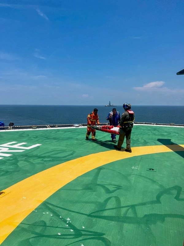 Coast Guard Air Station New Orleans aircrew and motor vessel Solitaire crew carry a Solitaire crewmember on a litter to a Coast Guard MH-60 Jayhawk helicopter May 16, 2023 near Port Fourchon Louisiana. The crewmember was reportedly experiencing heart attack-like symptoms and was in need of a medevac. (U.S. Coast Guard photo by courtesy asset)