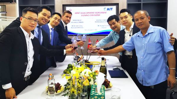 Mainstream's Development Director in Vietnam, Bernard Casey, centre left, and AIT Director Hoang Thanh Hai, centre right, lead their teams in toasting the new joint venture agreement at the signing ceremony in Hanoi - Credit: Mainstream Renewable Power