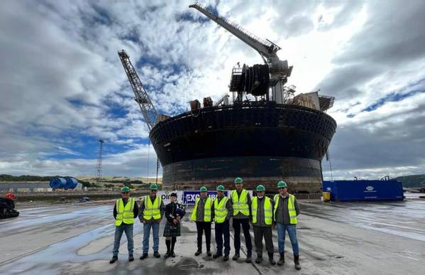 Representatives from DNeX and Ping in front of newly renamed FPSO to Excalibur. Photo from DNeX.