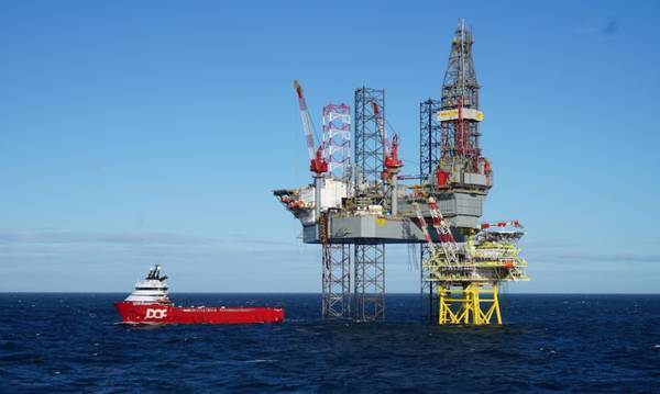 Tolmount platform with drilling rig and a standby vessel - Credit: Harbour Energy