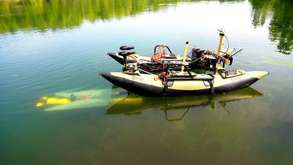 A yellow underwater robot (left) finds its way to a mobile docking station to recharge and upload data before continuing a task. (Purdue University photo/Jared Pike)